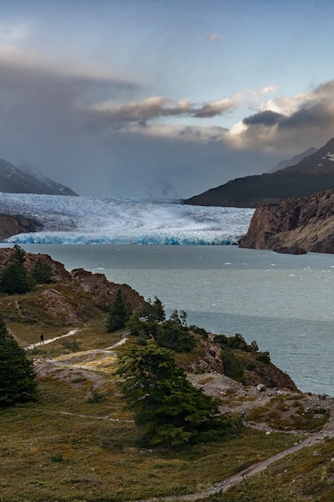 On the vast landscape of the Grey Glacier miniature-looking tourists are seen trekking